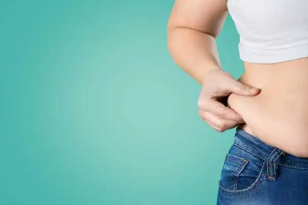 Image of woman pinching her love handles to show weight gain Broomhill